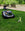 EGO AURA-R2 robot mowers using its in-built obstacle detention and avoidance system to navigate around a toy dinosaur on a lawn